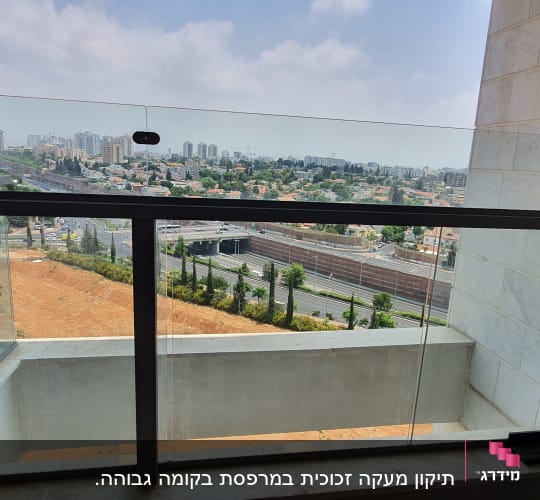 מעקה זכוכית במרפסת עם נוף עירוני